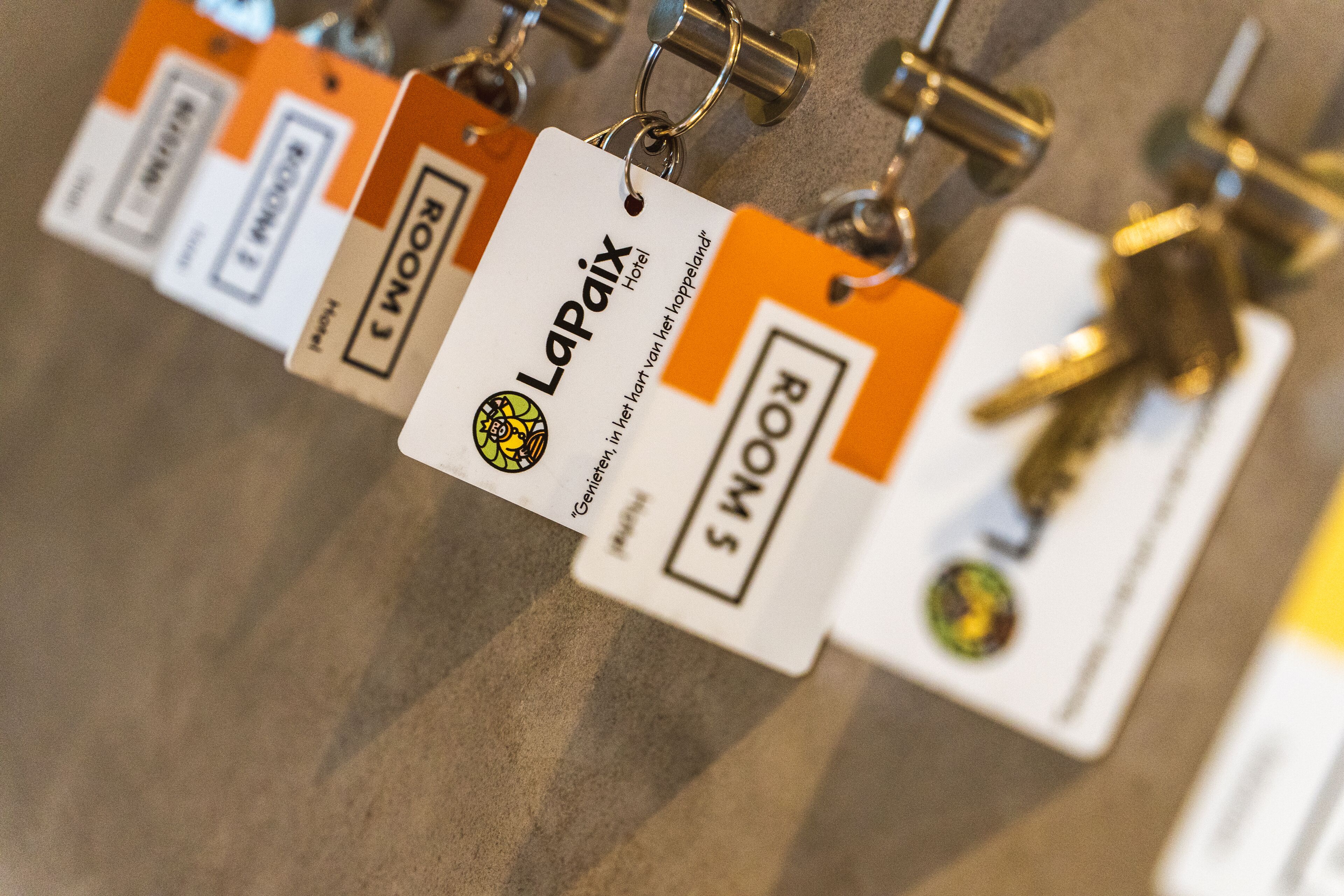 A row of keycards with the text "La Paix Hotel" and "Room 5" visible.