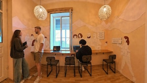 Una habitación con piso de madera, un ventanal con vista y una pared decorada con un mural.