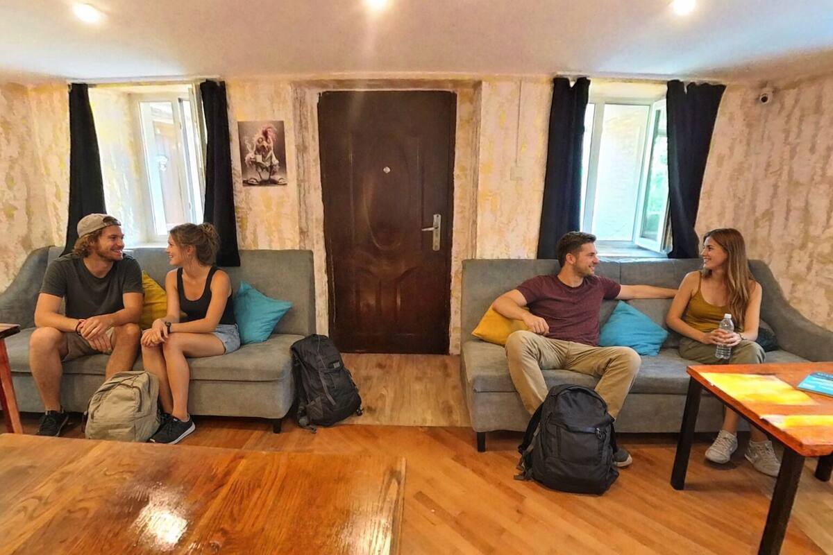 Une pièce avec deux canapés, une table en bois et une porte.