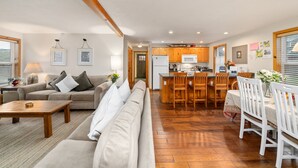 A spacious living room with a sofa, coffee table, and dining area with chairs and a table. - Treasure Paradise MCA#522-Only 1 1/2 blocks to the beach. Close to everything (Manzanita)