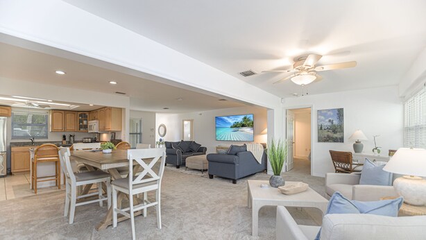 A spacious living area with a dining table, sofas, and a TV. - Beachside Bliss in The Moorings | 3BR Naples Stay (Naples)