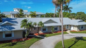 A residential area with multiple houses, each with a distinct architectural style, featuring gabled roofs and various window designs. - Beachside Bliss in The Moorings | 3BR Naples Stay (Naples)