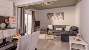 A modern living room with a grey sofa, a coffee table, and a TV.