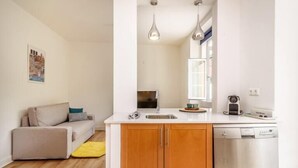 A compact living space with a kitchenette, a sofa, and a dining area.