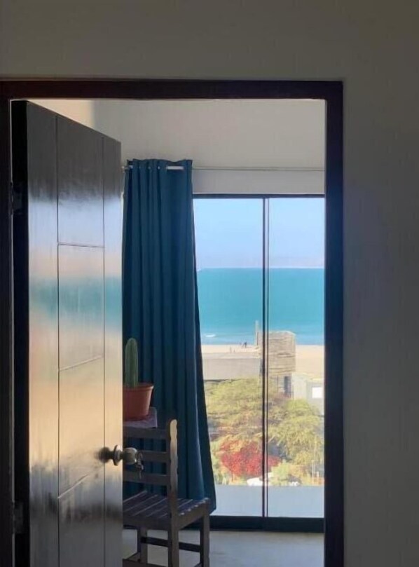 Enjoy ocean views from the balcony, featuring a chair and a potted plant.