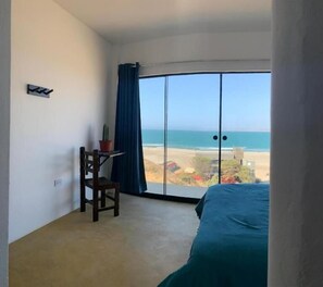 Enjoy stunning beach views from the comfort of your room, featuring a spacious bed and a cozy seating area.