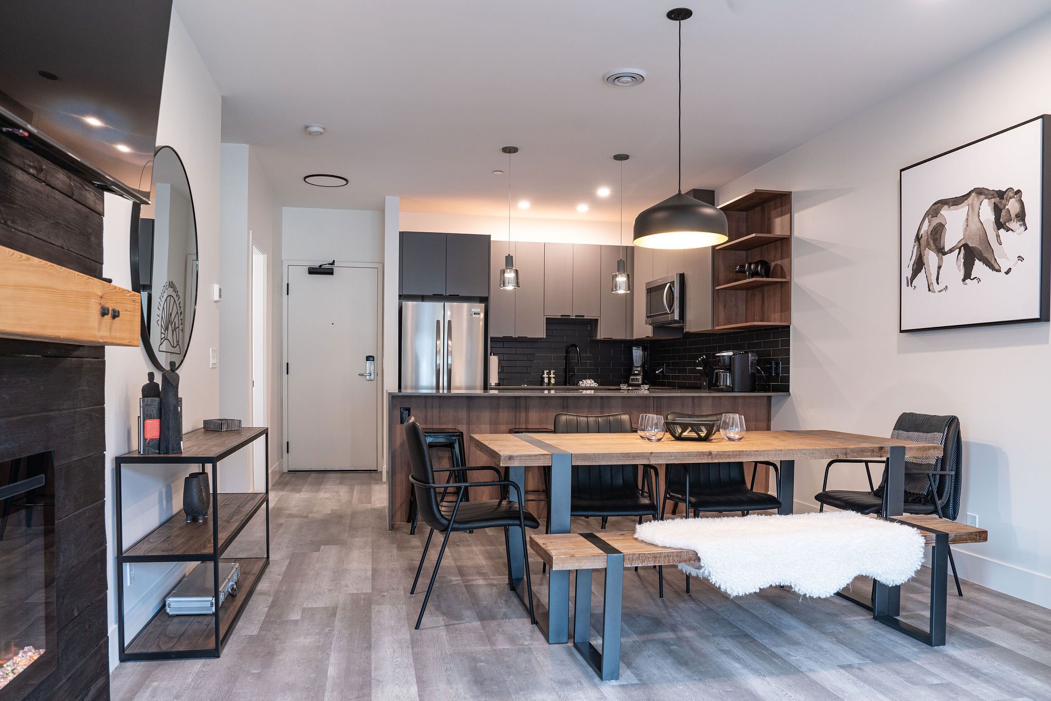 A modern kitchen with a central island, built-in appliances, and pendant lighting.