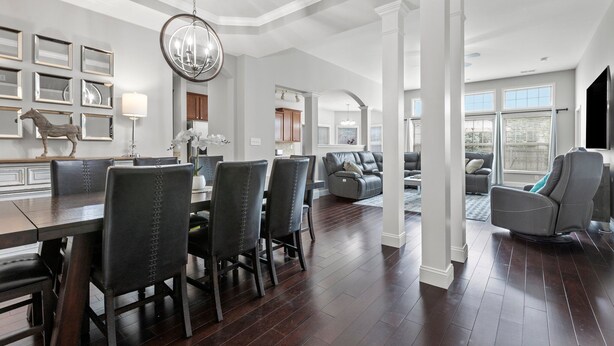 A spacious living room with a dark wood floor, a large gray sectional sofa, and a gray leather recliner. - Equine Escape - 3BR - BBQ Grill - 2-Car Garage (Lexington)