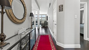 A hallway with a red carpet, a large mirror, and a sign prohibiting smoking and vaping. - Equine Escape - 3BR - BBQ Grill - 2-Car Garage (Lexington)