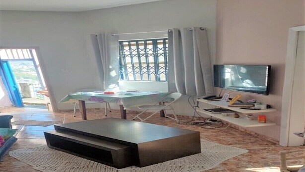 A living room with a TV, a dining table, and a sofa.