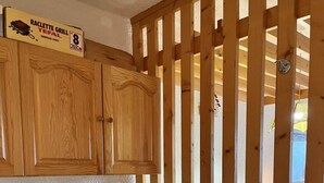Une cloison en bois sur laquelle est fixé un panneau indiquant la présence d’un appareil à raclette.