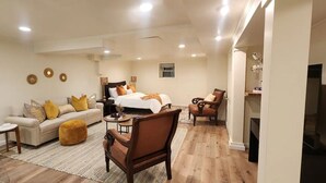 Ein modernes Schlafzimmer mit einem großen Bett, einer Couch, einem Sessel und einem kleinen Tisch.
