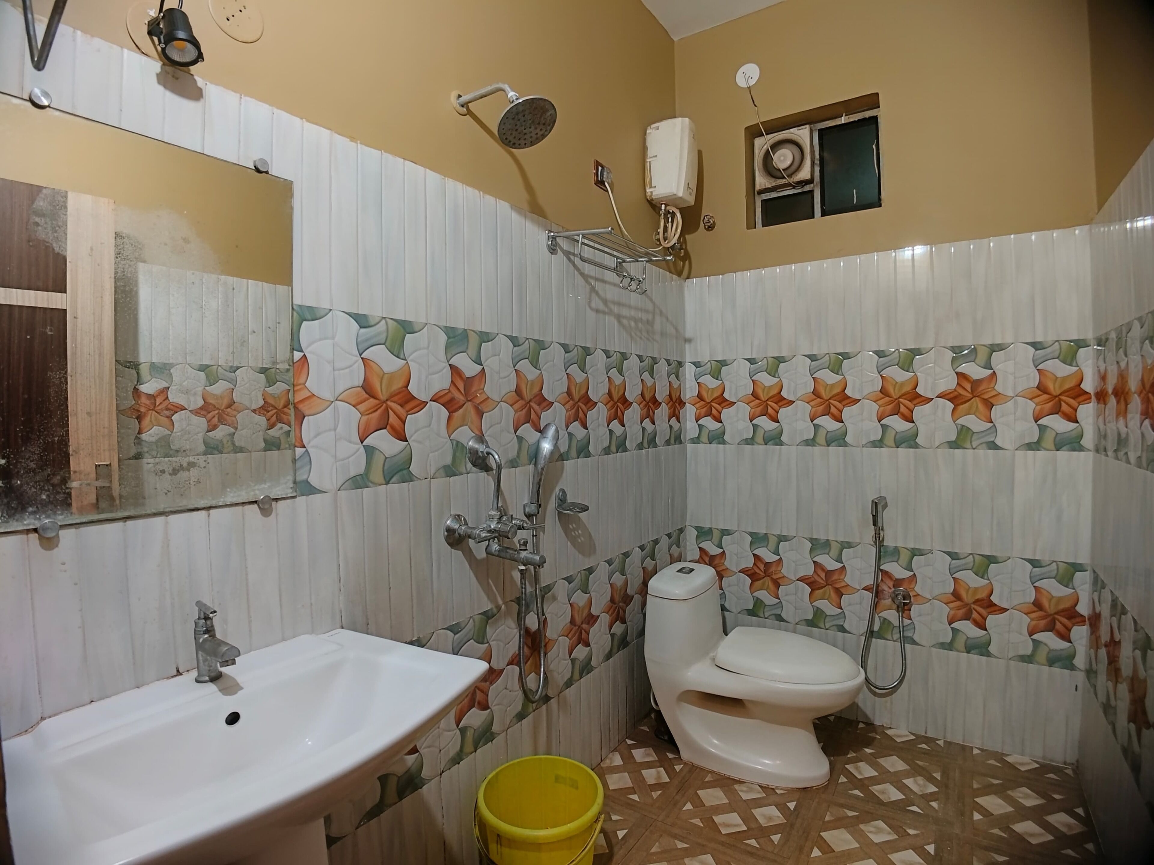Ein Badezimmer mit Waschbecken, Toilette, Dusche und einem kleinen Fenster.