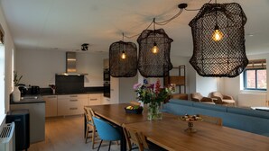 Une cuisine moderne avec un coin repas, comprenant une table en bois, des chaises et un canapé bleu.