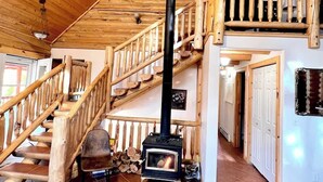 Un intérieur en bois avec un escalier, une cheminée et une décoration rustique.