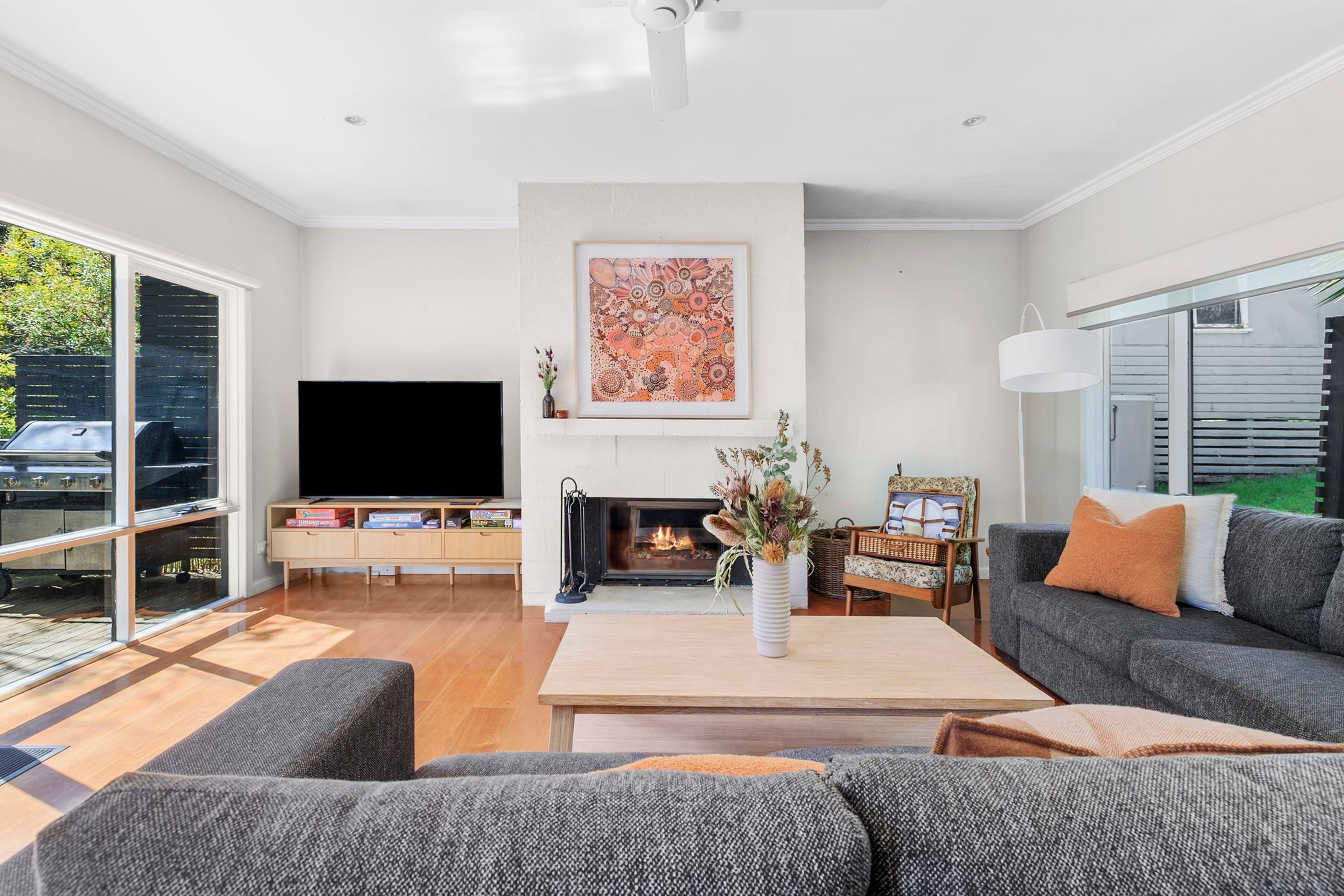 A modern living room with a fireplace, a television, and a sofa.