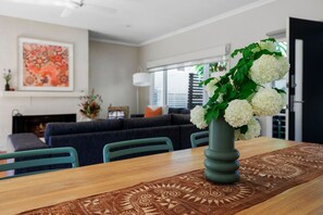 Un comedor con una mesa, sillas y un florero.