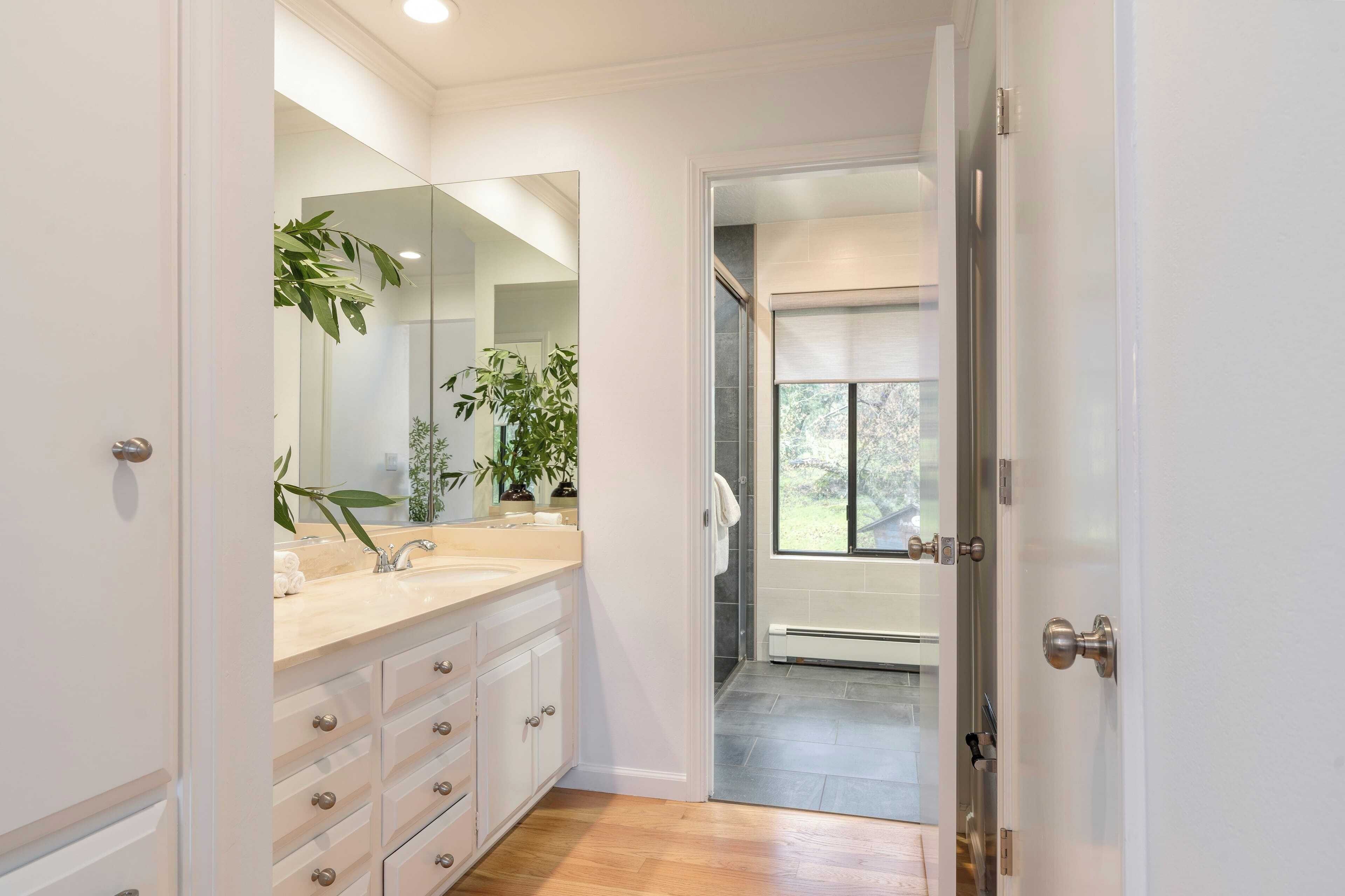 Une salle de bain moderne avec un grand miroir, un lavabo et une douche.