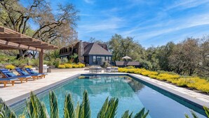 A swimming pool with lounge chairs, a pergola, and a house with a stone facade. - Malvasia by Avantstay Luxe Wine Country Retreat (Santa Rosa)