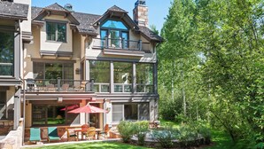 A two-story house with a balcony, outdoor seating, and a well-maintained garden. - Two Creeks by Snowmass Vacations (Snowmass Village)
