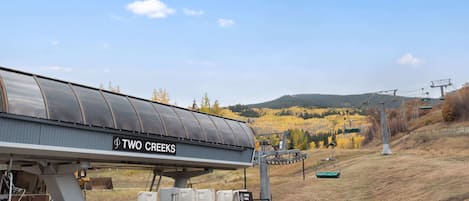 A ski lift station named "Two Creeks" with a covered waiting area and a chairlift in the background.
