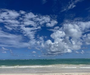 En strand med klare himmel og bølger.