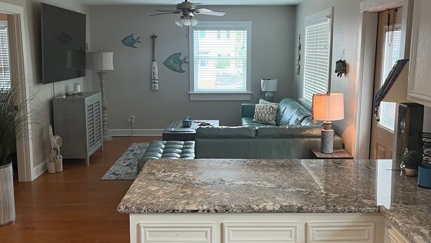 A spacious kitchen with white cabinetry, a granite countertop, and a ceiling fan. - Perfect historic location between beach and strand  (Galveston)