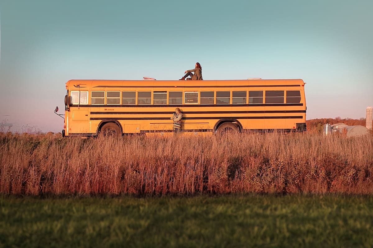 A yellow school bus parked in a grassy field.