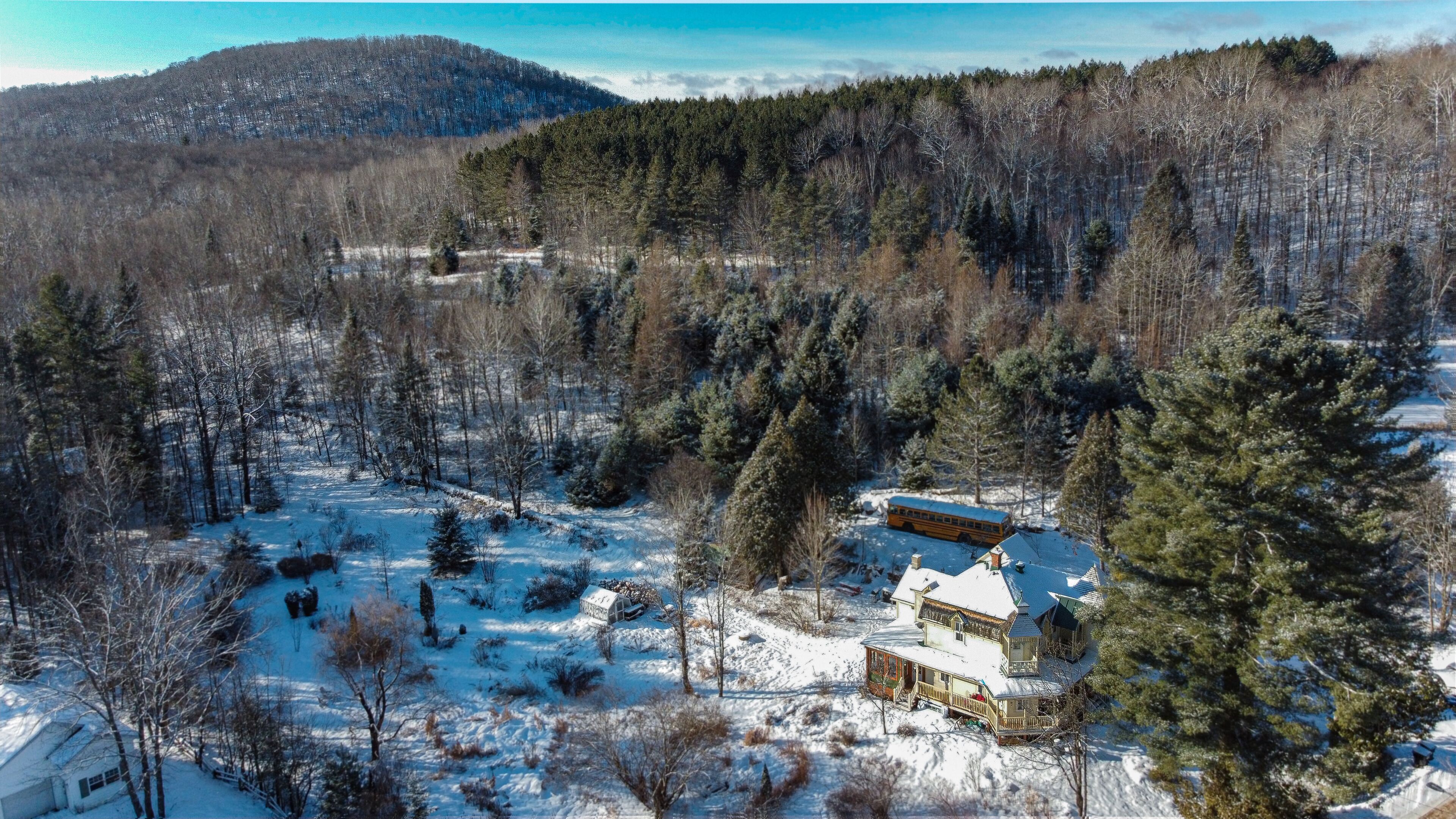 A snow-covered landscape with a cabin and a bus.