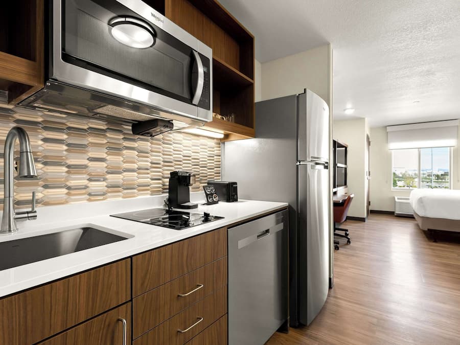 A modern kitchen with a built-in microwave, stainless steel refrigerator, and a dishwasher.