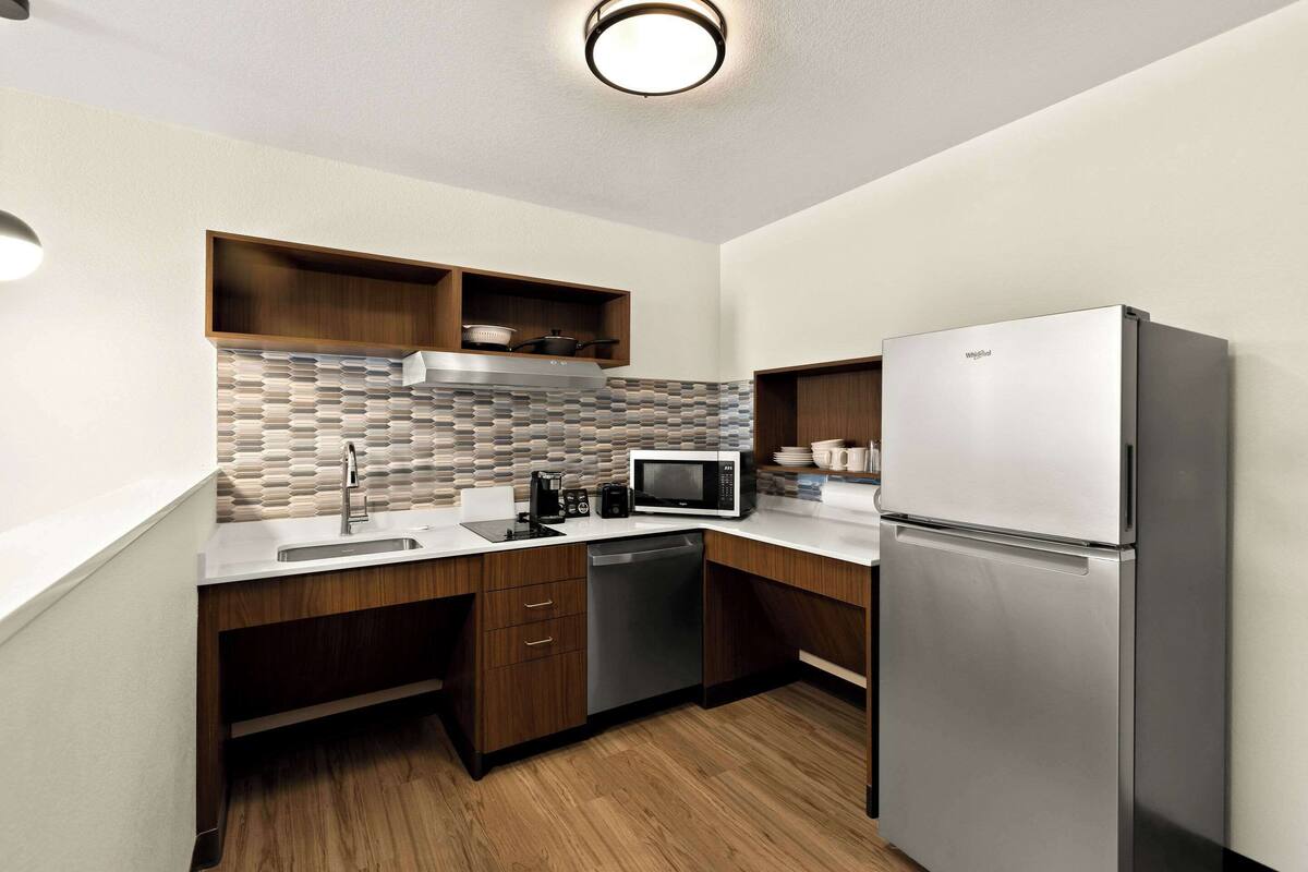 A modern kitchen with a stainless steel refrigerator, a microwave, and a dishwasher.