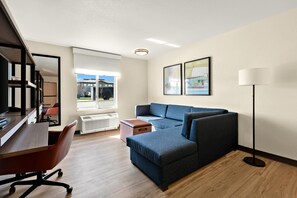 Een moderne woonkamer met een bank, een bureau en een stoel.