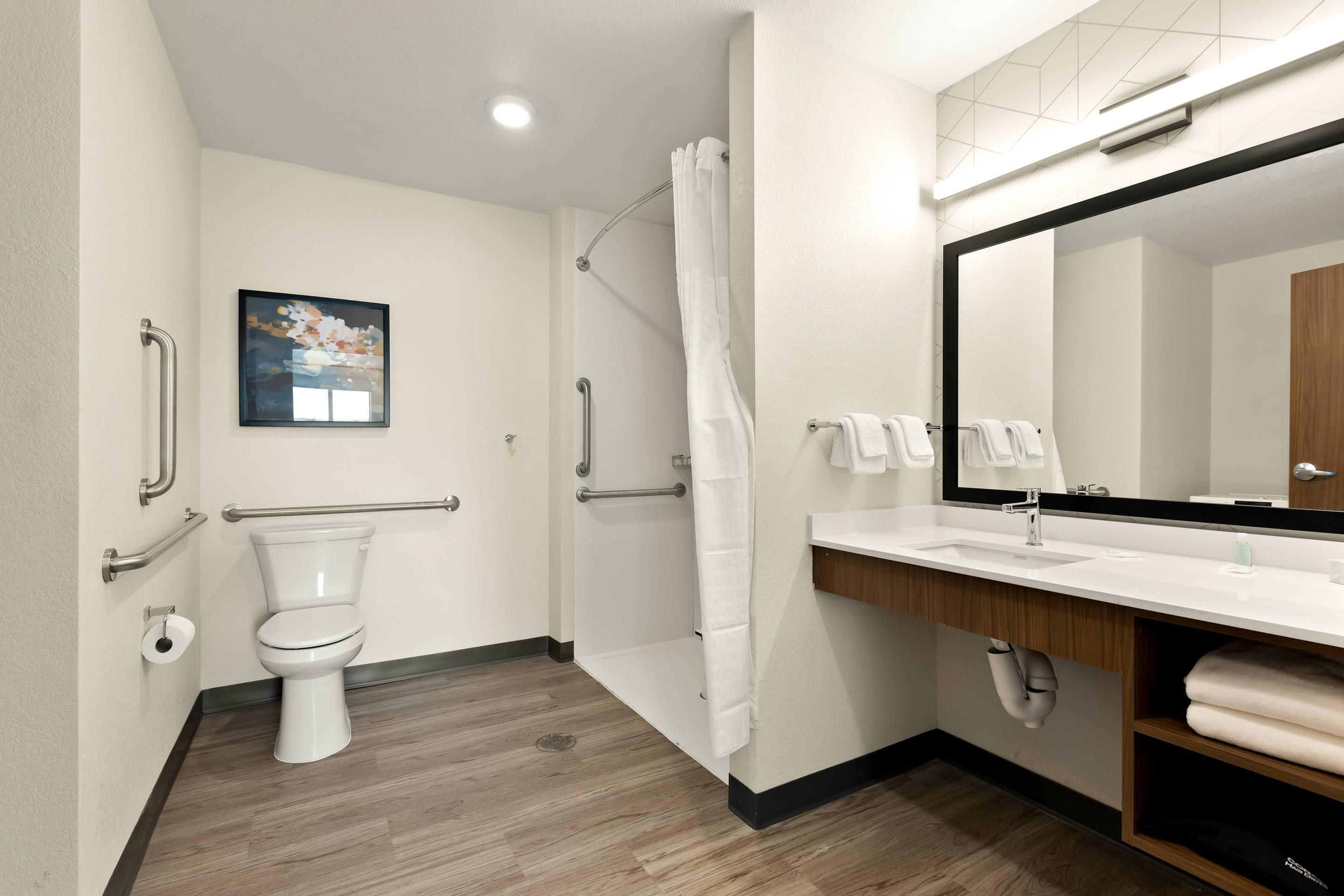 A modern bathroom with a toilet, shower, and sink.