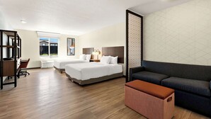 A hotel room with two beds, a desk, a sofa, and a large window. - Everhome Suites Nampa Boise (Nampa)
