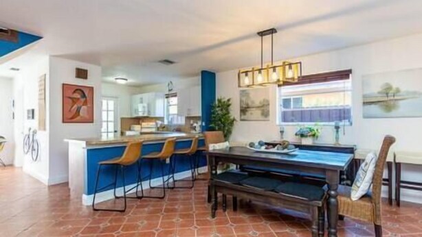 Une cuisine spacieuse avec un coin bar, une table à manger avec des chaises et une table de billard.