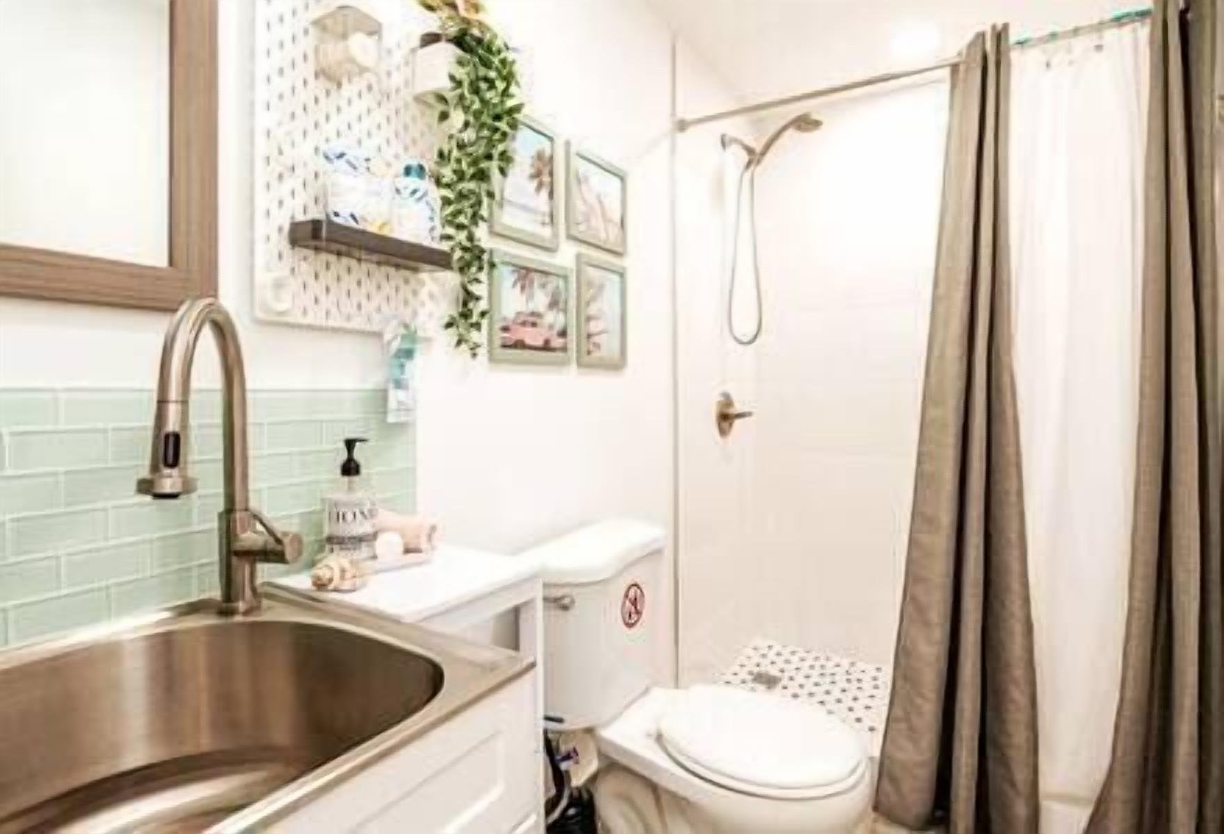 Une salle de bain équipée d’un lavabo, de toilettes, d’une douche et d’un porte-serviettes.