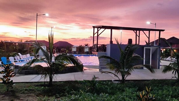 A pool area with lounge chairs, a covered seating area, and palm trees. - PUNTA COCO VILLAS BEACH (Cojimies)
