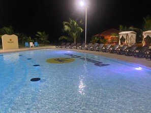 Una piscina con sillas de descanso y un letrero que dice "Punta Coco".