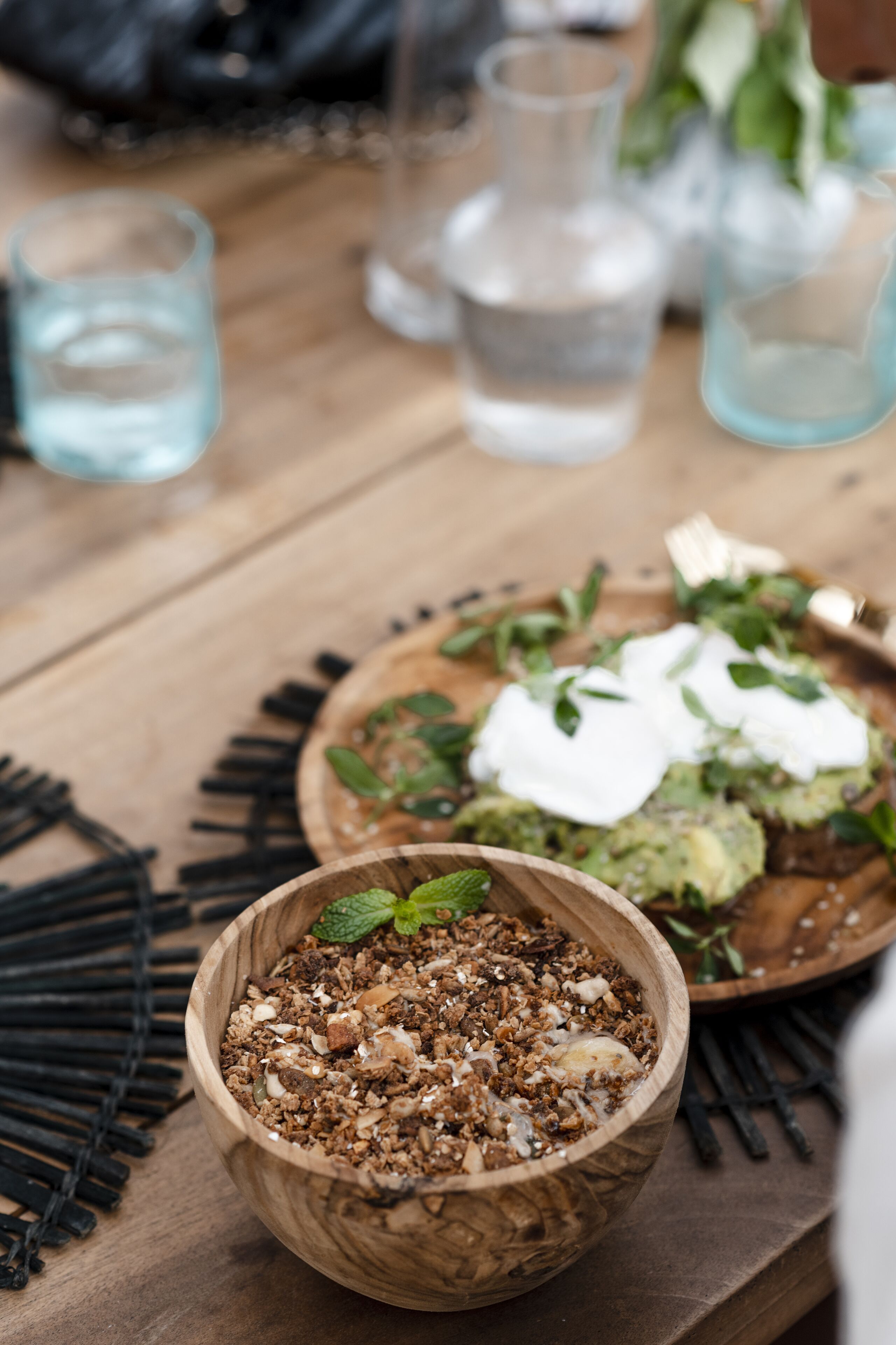 A wooden bowl filled with granola on a table.