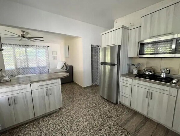 A modern kitchen with granite countertops, stainless steel appliances, and light-colored cabinetry.