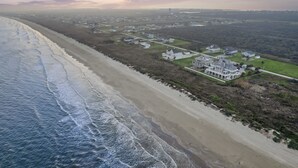 An aerial view of a coastal area with a beach, houses, and a large estate with multiple buildings. - New! Rare Mezzanine Deck, Hot Tub & Beach Views! (Crystal Beach)