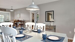 A dining area with a light blue table, white chairs, and blue placemats. - 4BR Home w/ Private Dock and Fenced Backyard and Firepit. Minutes from the Beach (St. Augustine)