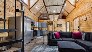 Un interior acogedor de cabaña con cocina, comedor y sala de estar.