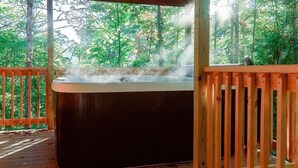 A hot tub on a wooden deck surrounded by trees. - 3 Cabins | 30+ | 3-Hot Tubs| DogOK | FirePit (Campton)