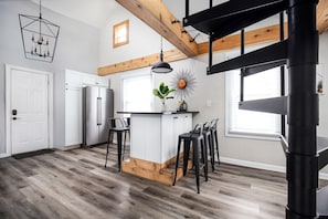 Enjoy cooking in this well-equipped kitchen with a central island, stainless steel appliances, and a convenient bar stool area.