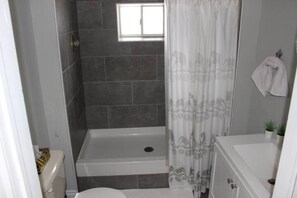 Ein Badezimmer mit Dusche, Toilette und Waschbecken.
