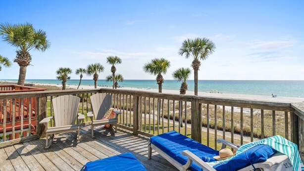 A wooden deck with lounge chairs and a view of the beach. - Sunny Beach by Book That Condo (Panama City Beach)