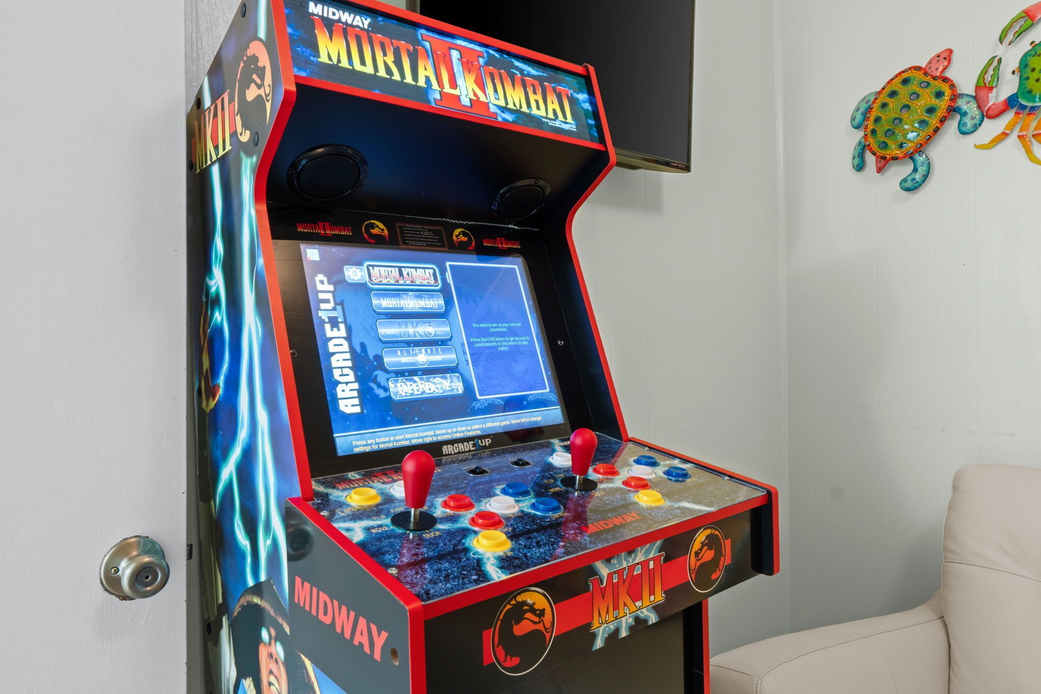 Une borne d’arcade de jeux vidéo dotée d’un écran affichant les options de jeu et de deux manettes.