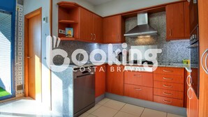 Eine moderne Küche mit Holzausbau, einem Edelstahlkühlschrank und einer Granitarbeitsplatte.