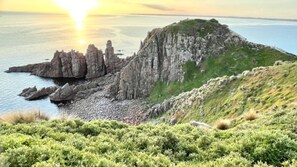 A coastal landscape with rocky cliffs and a grassy hill. - Number Thirty One Smiths Beach Phillip Island (Smiths Beach)